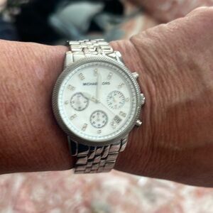 Women’s Michael Kors watch with rhinestone accents also has date.